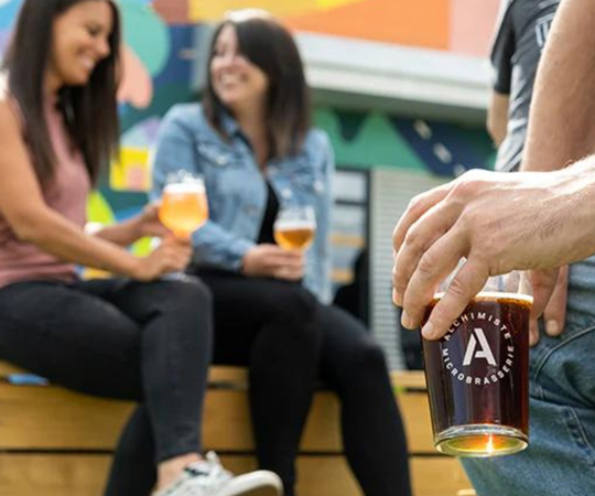 Découvrir la région Des personnes boivent une bière de l'Alchimiste, une marque de la région de Lanaudière